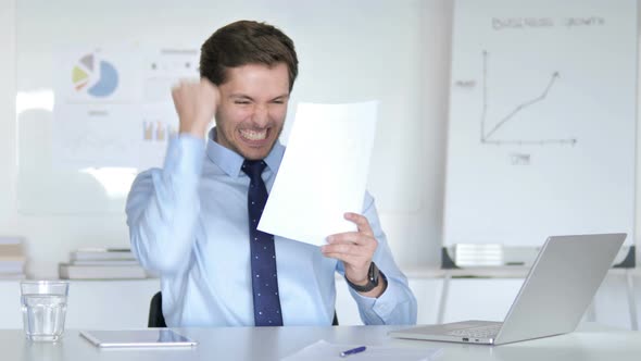 Happy Businessman Cheering for New Contract, Reading Documents