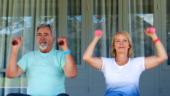 Senior couple exercising with dumbbells