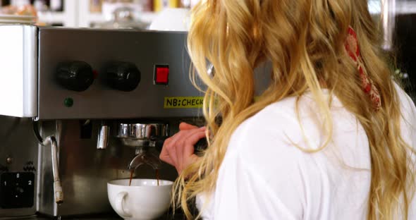 Portrait of smiling waitress making cup of coffee