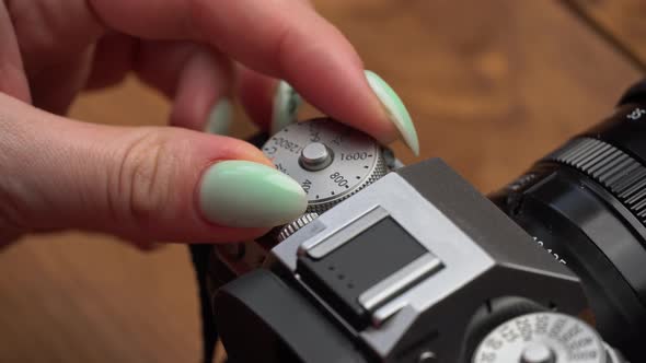 Girl's Hands are Spinning the Iso Wheel on a Vintage Camera Closeup