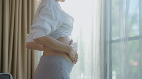 Asian beautiful pregnancy woman drink a glass of milk for health care.