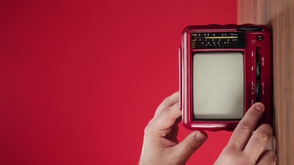 Vertical Video of Turning on Small Old Television with Grey Interference Screen on Red Background