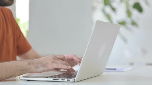 Close Up of Young Man Typing on Laptop Keyboard