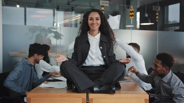 Working Chaos Office Multiracial Team in Background Young Balanced Hispanic Girl in Lotus Position