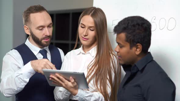 Multiethnic Business People Analyzing Information and Discussing Startup Project Using Tablet PC