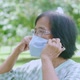 Portrait of Elderly old Asian woman taking off face mask in the park - VideoHive Item for Sale