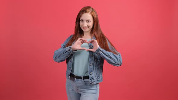 Happy Woman Make with Fingers Heart Shape, Isolated Over Red Background.