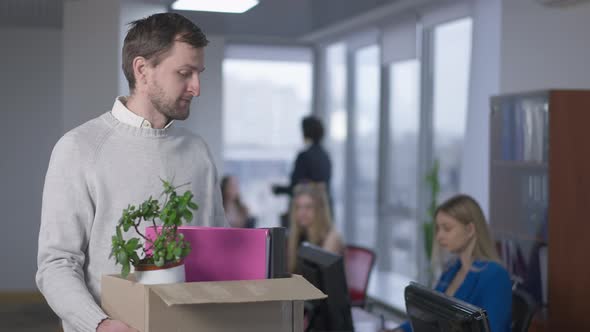 Portrait of Jobless Frustrated Caucasian Man Posing with Box in Office