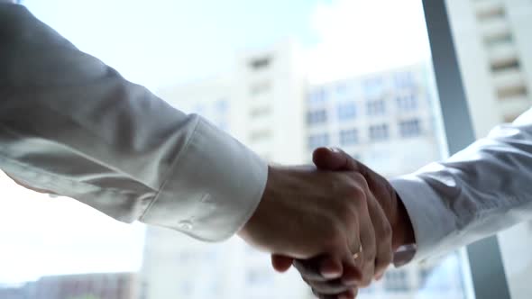 Close-up of Handshaking of Two Partners African American Business Man and Caucasian Businessman.