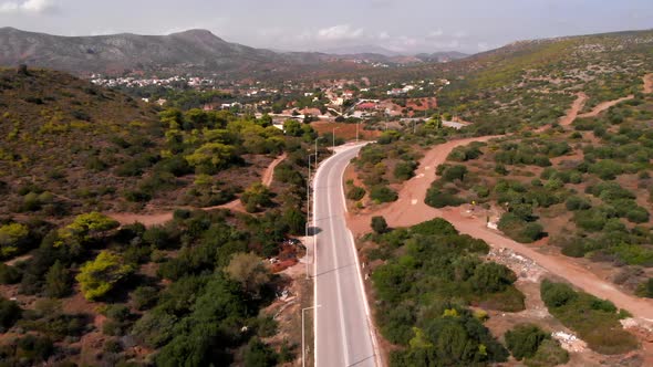 Silver bus driving on road at Cape Sounion, forward aerial