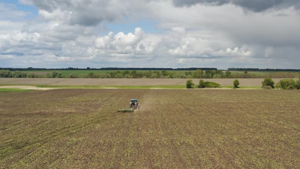 A Tractor with a Cultivator Working in the Field, Aerial View