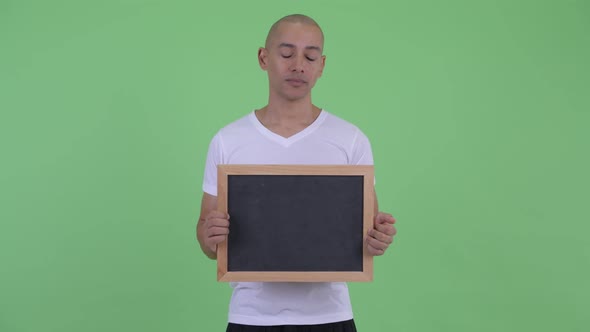 Stressed Bald Man Holding Blackboard and Getting Bad News