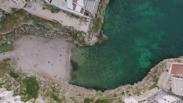 Static overhead aerial footage of the beach cove of Lama Monachile in Polignano a Mare, Italy.