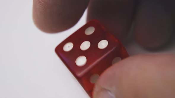 Young Man Turns Dice with Symbols Five on White Background