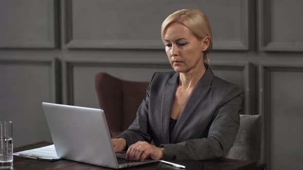 Caucasian Female Manager Working on Laptop during Client Meeting