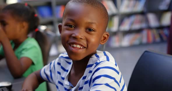 Front view of African american schoolboy studying on computer in the classroom 4k