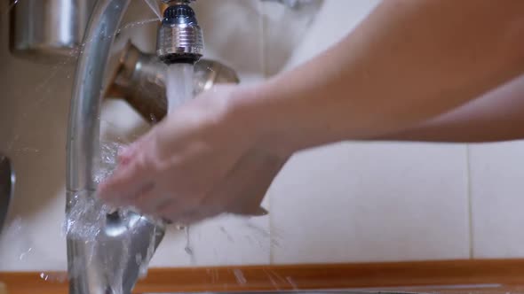 Woman Washes Hands Under a Strong Stream of Running Water Closes Tap