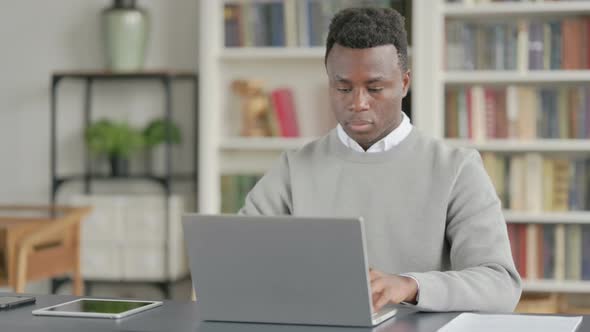 African Man Having Headache While Working on Laptop