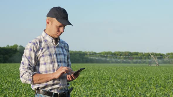 Farmer Uses a Smartphone in the Field