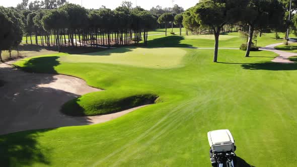 Flying over and following golf cart in golf course field, Turkey