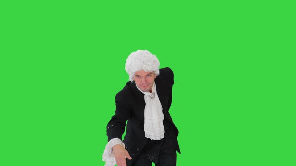 Man in Old-fashioned Laced Frock Coat and White Wig Making a Bow Looking at Camera on a Green Screen