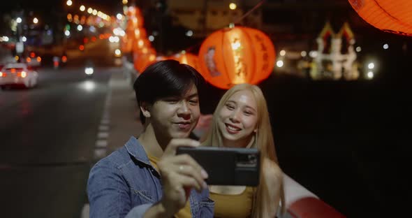 Young Asian couple travel make a video live streaming on social network by smartphone.