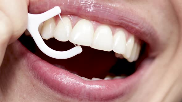 close up4 k video woman mouth smiling and flossing her teeth with white plastic toothpick. beautiful