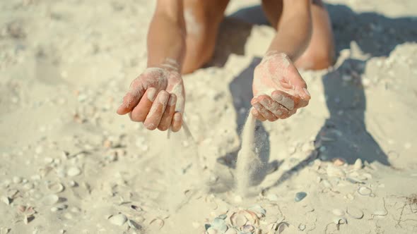 CLOSE UP Unknown Playful Young Woman Throws a Handful of White Sand Over the Camera