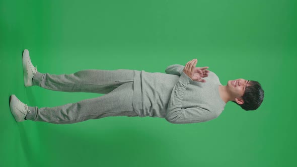 Full Body Of Side View Asian Man Clapping Her Hands In The Green Screen Studio