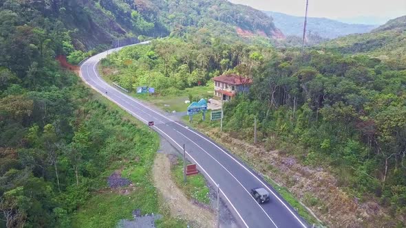 Flying Camera Shows Car Driving Along Mountain Road and Motel