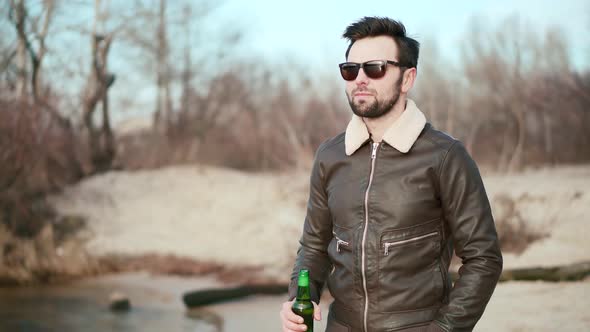 Relaxed Handsome Man Drinking Beer. Cheerful Man Celebrating And Drinking Cold Beer Outdoors.
