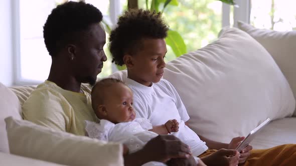 Black Dad Bonding with Kids and Watching Video Browsing Tablet Device Gadget Spbi