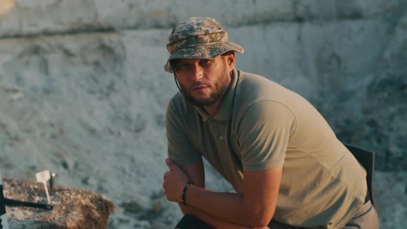 Male Archaeologist Sitting on Digging Site