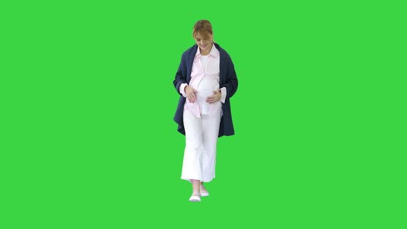 Happy and Proud Pregnant Woman Looking at Her Belly While Walking on a Green Screen, Chroma Key