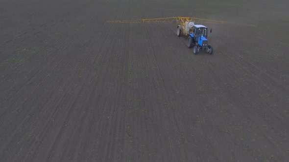 The Tractor Spreads Fertilizer Through the Field, Shooting From the Air