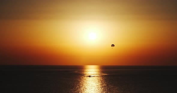 parasailing parascending parakiting,paragliding at cinematic sunset by boat in ten bit four k sixty