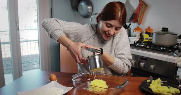 Girl is Mashing Boiled Potatoes for the Preparation of Dumplings and Croquettes