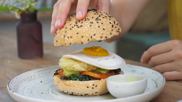 Person Puts Gluten Free Bun on Top of Plant Based Burger