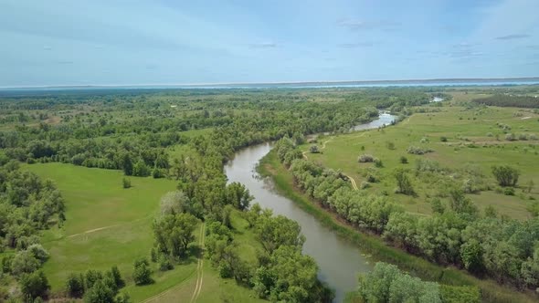 Flight Over Green Meadow, Forest and River in Spring