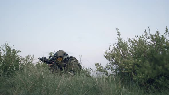 Sniper in Military Uniform Lies Down in Grass Takes Aim at Eyepiece of Sniper Rifle Gets Up and Runs alt