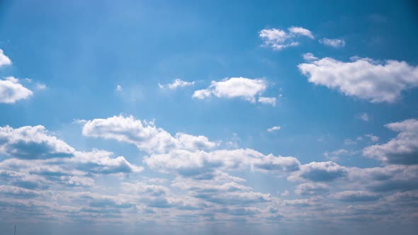 Timelapse White Fluffy Olakas Float Through the Blue Sky on a Sunny Day