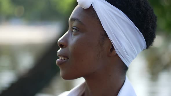 Side View Closeup Smiling African American Woman Looking Away with River Water Waves at Background