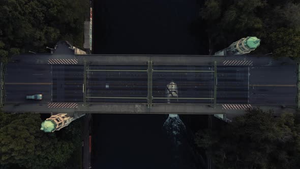 Drone Rising Slow Overhead Montlake Cut Bridge With Boat And Cars Cruising At Golden Hour