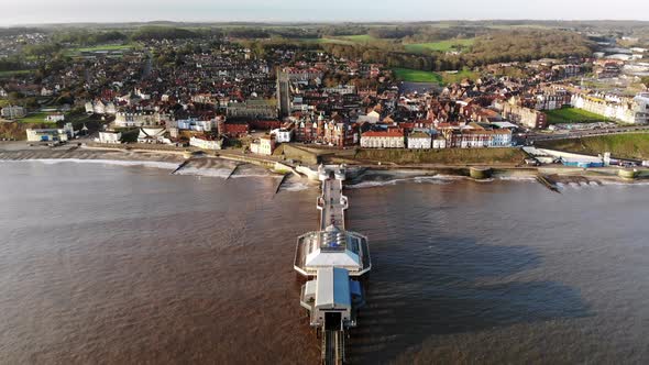 Drone footage from the sea flying over the pier at Cromer, Norfolk towards the town in early morning