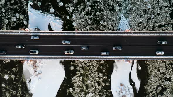Aerial Top Down View Of Cars Driving On Bridge Over The River In Winter alt