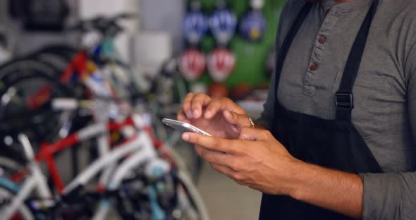 Mechanic using mobile phone in workshop