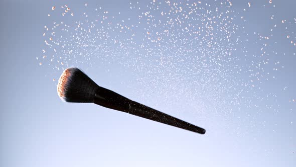 Super Slow Motion Shot of Flying and Rotating Makeup Brush and Brown Powder at 1000Fps