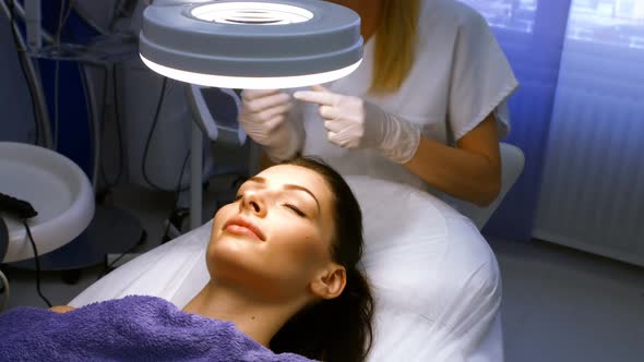 Doctor inserting facial injection on female patient forehead