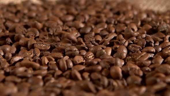 Roasted Coffee Beans and Falling on Burlap Sacking Background, Rotation, Cam Moves To the Left, Slow
