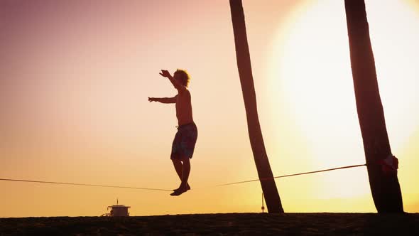 Lens flare shot of a man balancing on the slackline near Venice Beach, California